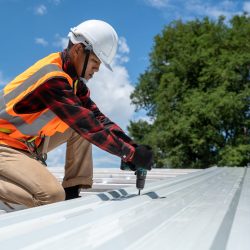 The Roofer technicians work and installing new roof structure on top roof of house,metal roof,fasteners corrugated sheets.