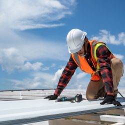 Roofer working in protective work wear gloves,Construction worker wearing safety harness working at high level in the construction site install new roof,metal roof.
